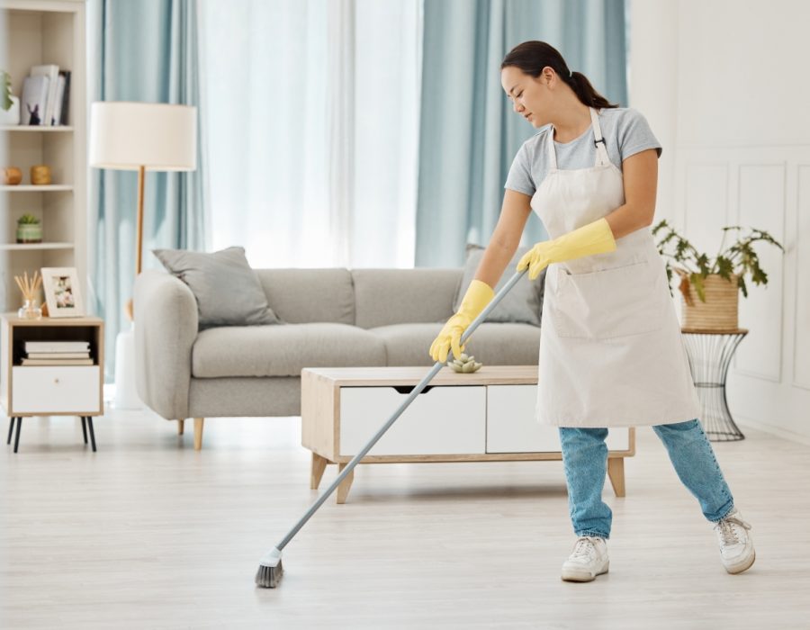 person sweeping the floor of a living space